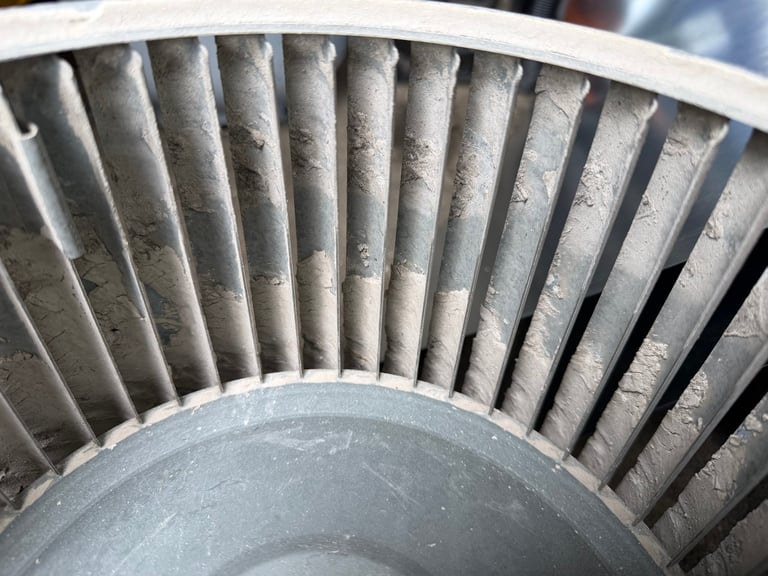 Close-up of metal turbine blades arranged in a circular fan pattern with a gray center hub