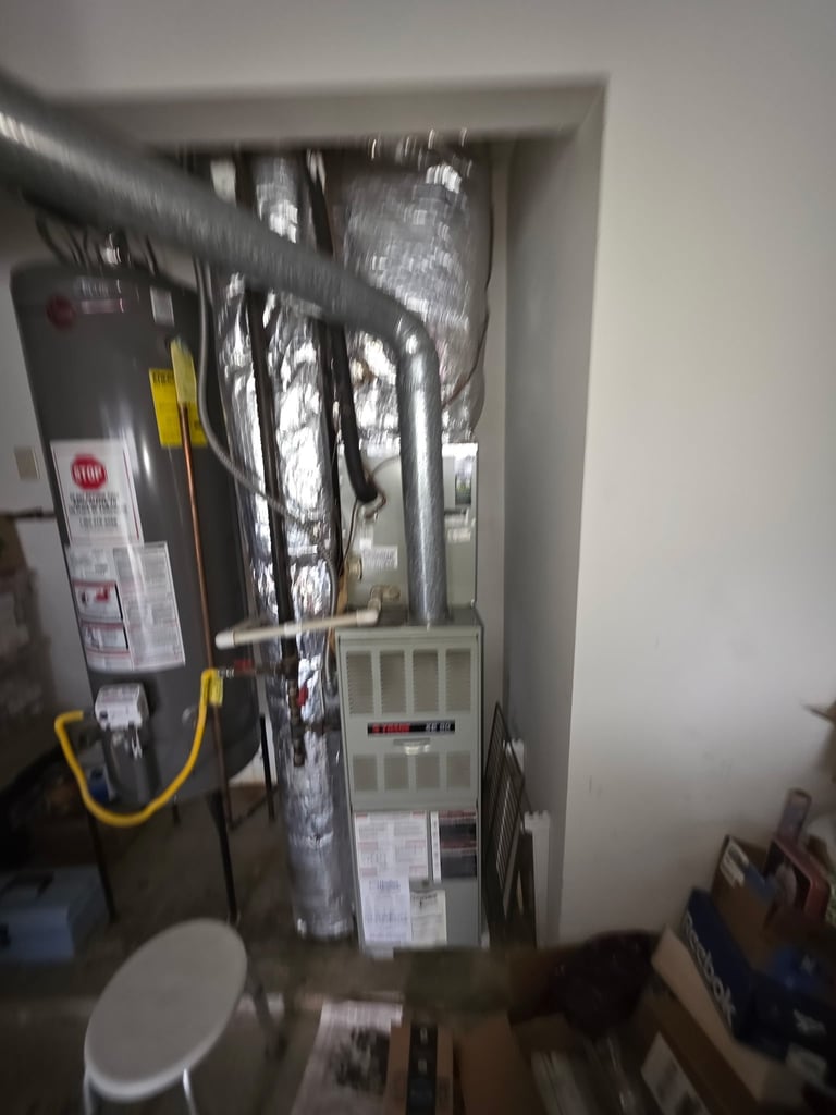 Cluttered electrical panel and utility closet with insulation, wires, and control equipment mounted on wall