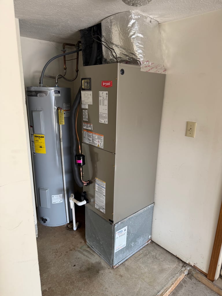 Basement utility closet with HVAC system, water heater, and ductwork installation in progress